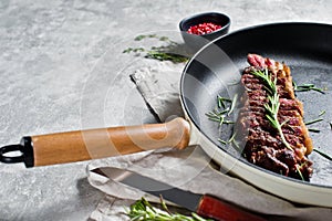 Beef rump steak roasted rear in pan. Grey background, top view.