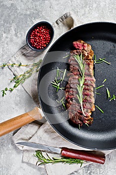 Beef rump steak roasted rear in pan. Grey background, top view.