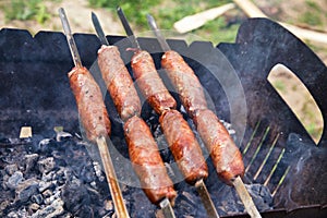 Beef sausages grilled on a coals. Barbecue on brazier.