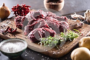 Beef shank for stew cut to big chunks with herbs, spices, salt and vegetables ready for cooking