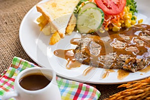 Beef steak with black pepper sauce , salad and French fries on s