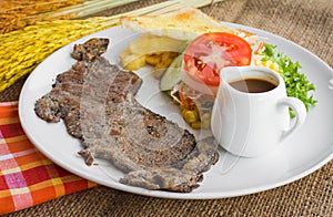 Beef steak with black pepper sauce , salad and French fries on s