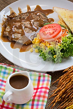 Beef steak with black pepper sauce , salad and French fries on s