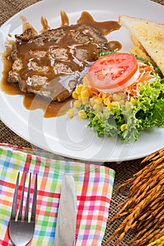 Beef steak with black pepper sauce , salad and French fries on s