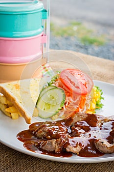 Beef steak with black pepper sauce , salad and French fries on s