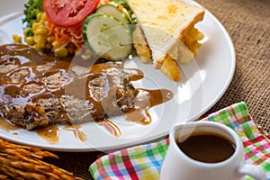 Beef steak with black pepper sauce , salad and French fries on s