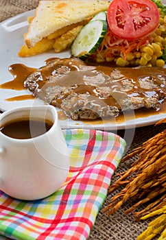 Beef steak with black pepper sauce , salad and French fries on s