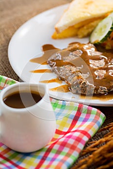 Beef steak with black pepper sauce , salad and French fries on s