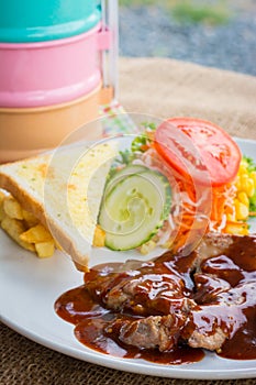 Beef steak with black pepper sauce , salad and French fries on s