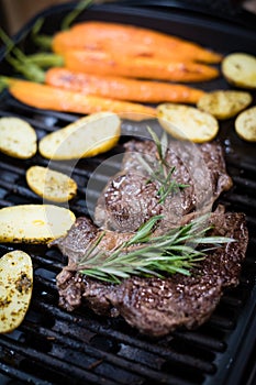 Beef steak with carrot and sweet potato on the grill