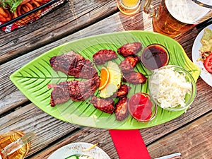 Beef steak with chicken wings and white cabbage salad