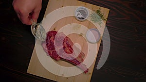 Beef steak drizzled with olive oil in slow motion