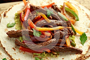 Beef Steak Fajitas with tortilla mix pepper, onion and avocado on wooden board