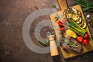 Beef steak grilled with vegetables on cutting board