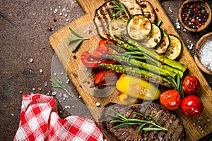 Beef steak grilled with vegetables on cutting board