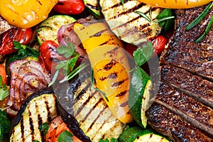 Beef steak and Grilled vegetables. On cutting dark board background