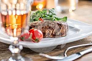 Beef Steak. Juicy beef steak. Gourmet steak with vegetables and glass of rose wine on wooden table