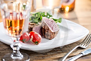 Beef Steak. Juicy beef steak. Gourmet steak with vegetables and glass of rose wine on wooden table