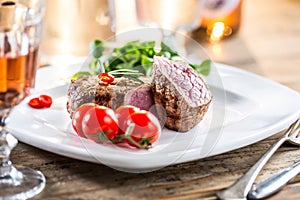 Beef Steak. Juicy beef steak. Gourmet steak with vegetables and glass of rose wine on wooden table