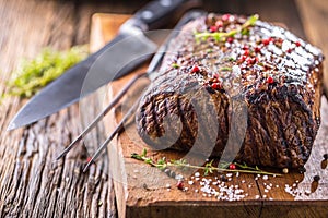 Beef steak. Juicy Rib Eye steak in pan on wooden board with herb and pepper