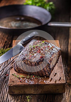 Beef steak. Juicy Rib Eye steak in pan on wooden board with herb and pepper