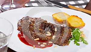 Beef steak with ketchup and pine nuts, served with potatoe