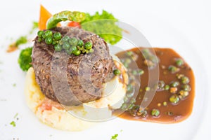 Beef steak on mashed potatoes with black pepper sauce
