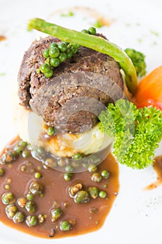 Beef steak on mashed potatoes with black pepper sauce