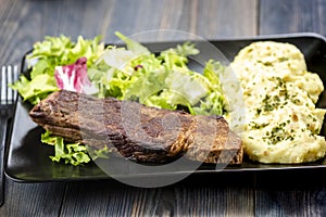 Beef steak with mashed potatoes and rocket salad