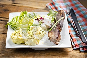 Beef steak with mashed potatoes and rocket salad