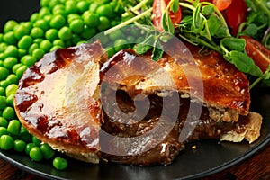 Beef steak pies with rich onion gravy served with sweet peas and salad