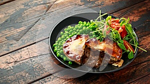 Beef steak pies with rich onion gravy served with sweet peas and salad