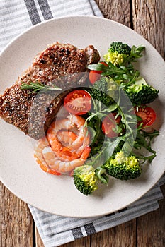 Beef steak with prawns and broccoli, tomatoes, arugula closeup o