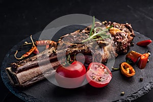 Beef steak with rosemary, chili peeper and tomatoes on slate board