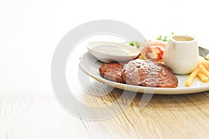 Beef steak, salad and french fries on a vintage wood background