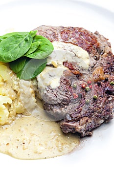 beef steak with sauce, mashed potatoes and spinach leaves