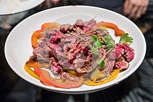 Beef steak sliced with tomato and potato on white plate