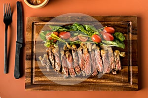 Beef steak on a wooden background. Sliced grilled meat barbecue steak Strip loin with knife and fork carving set on wooden Cutting