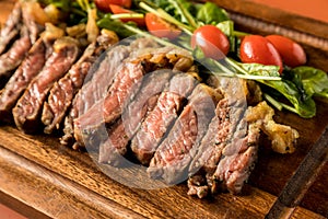 Beef steak on a wooden background. Sliced grilled meat barbecue steak Strip loin with knife and fork carving set on wooden Cutting