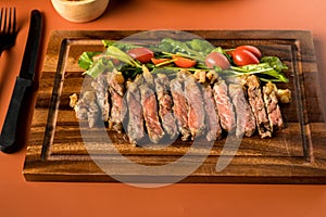 Beef steak on a wooden background. Sliced grilled meat barbecue steak Strip loin with knife and fork carving set on wooden Cutting