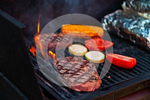 Beef steaks on the grill with flames