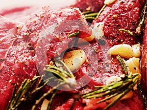 Beef steaks marinated for barbeque with olive oil, garlic, rosemary and herbs. Close up, Selective focus