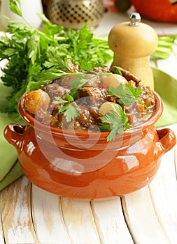 Beef stew with vegetables and herbs in a clay pot