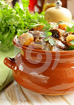 Beef stew with vegetables and herbs in a clay pot