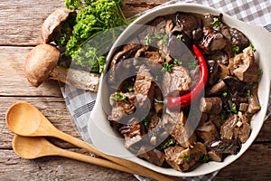 Beef stew with wild mushrooms, onion and chili pepper close up i