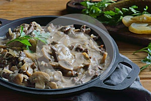 Beef Stroganoff in a frying pan on a wooden background