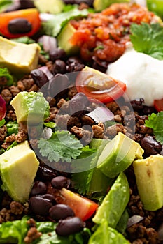 Beef Taco salad with romaine lettuce, avocado, tomato salsa, black bean and tortilla chips. Mexican healthy food