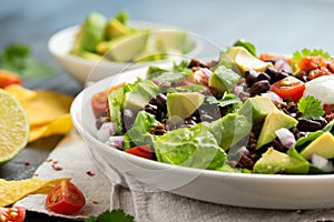 Beef Taco salad with romaine lettuce, avocado, tomato salsa, black bean and tortilla chips. Mexican healthy food