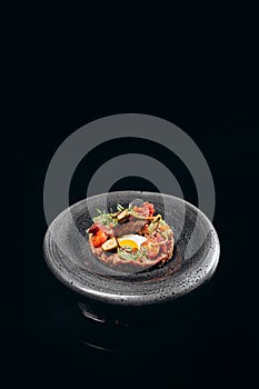 Beef tartare appetizer on a black background
