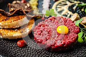 Beef tartare from Black Angus. Onion, quail egg, tomato sauce, mustard mayonnaise. Delicious healthy Italian traditional